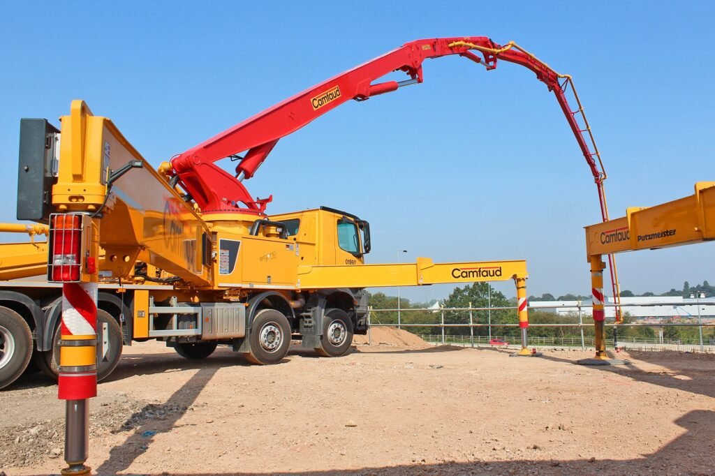 Red concrete boom pump on a job site